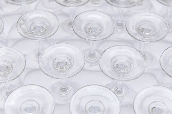 File di fondi vuoti di vetro di vino su tavolo bianco — Foto Stock