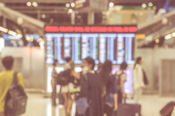 Borrosa de Traveler en la terminal del aeropuerto con horario de vuelo boa — Foto de Stock