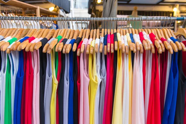 Moda ropa colorida cuelgan en un estante en las compras del mercado de pulgas — Foto de Stock