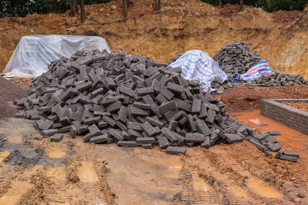 Кирпичи из черной глины для строительства на стройплощадке — стоковое фото