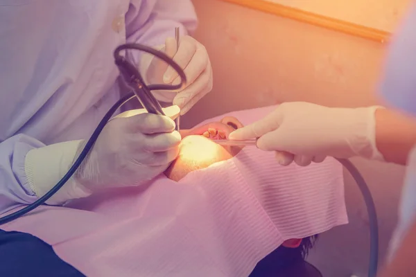 Dentist cleaning the teeth patient with ultrasonic tool — Stock Photo, Image