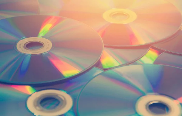 Conjunto de discos compactos coloridos de DVD espalhados em uma mesa — Fotografia de Stock