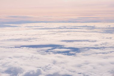 Mavi gökyüzü ve bulutlar uçağın penceresinden görüldüğü gibi