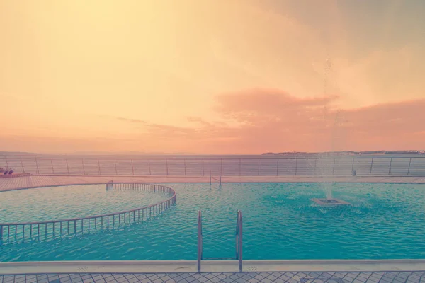 Piscine de luxe en face de la mer au coucher du soleil — Photo