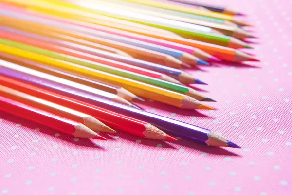 Barevné tužky izolované na pozadí růžové látky — Stock fotografie
