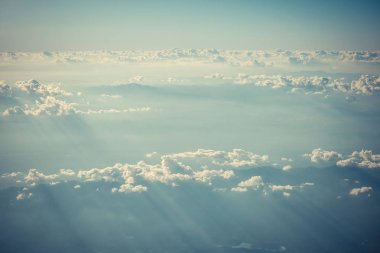 Mavi gökyüzü ve bulutlar uçağın penceresinden görüldüğü gibi