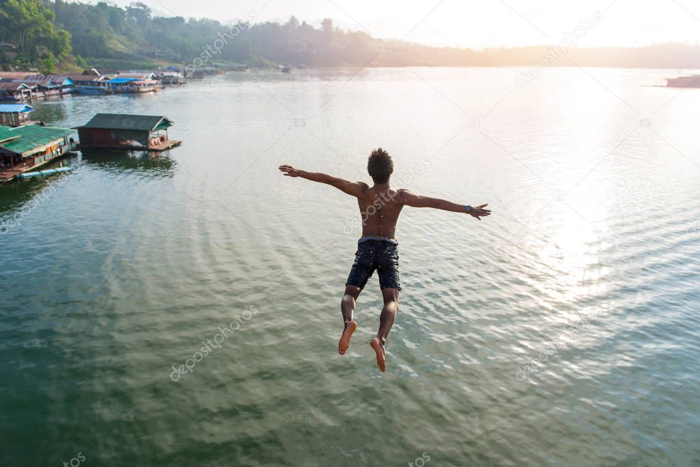 Man jumping into lake retro on Longest wooden bridge in sangkhla