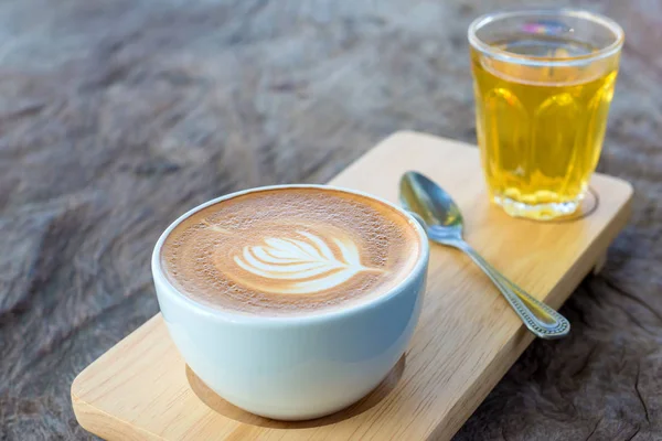 Latte konst kaffe eller cappuccino på träbord bakgrund — Stockfoto
