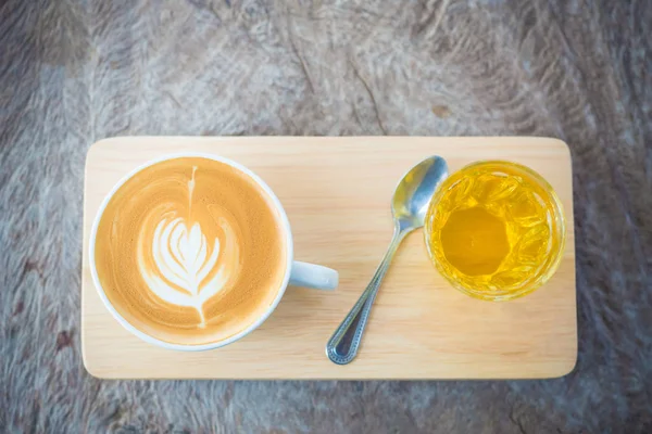 Kawa latte art lub cappuccino na drewnianym tle stołu — Zdjęcie stockowe