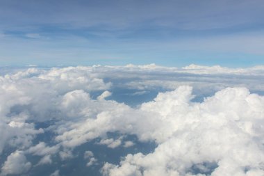 Mavi gökyüzü ve bulutlar uçağın penceresinden görüldüğü gibi