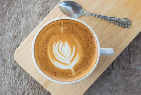 Café latte arte o capuchino sobre fondo de mesa de madera — Foto de Stock