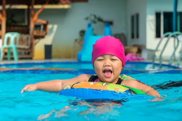 Cute girl or little child playing in swimming pool happily — Stock Photo, Image