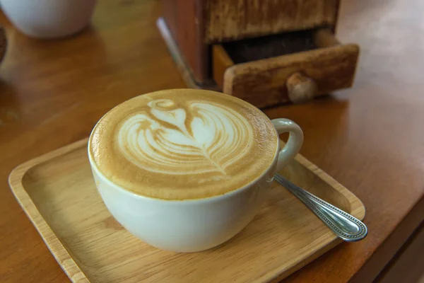 Café latte arte o capuchino sobre fondo de mesa de madera — Foto de Stock