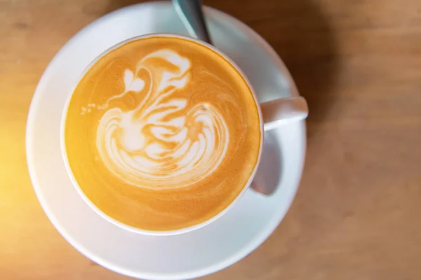 Kawa latte art lub cappuccino na drewnianym tle stołu — Zdjęcie stockowe