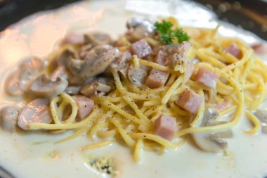 siyah çanak üzerinde mantar soslu spagetti