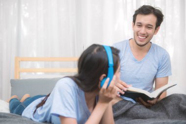 Çift rahatlatıcı müzik ve bir kitap okuma yatak odasında