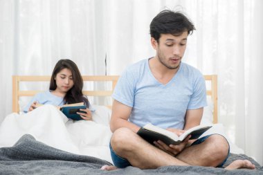 Genç seven çift yatak odalı evde üzerine bir kitap okuma