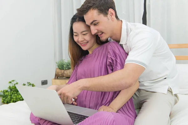 Kobieta w ciąży i jej przystojny mąż za pomocą notebooka, lifestyl — Zdjęcie stockowe