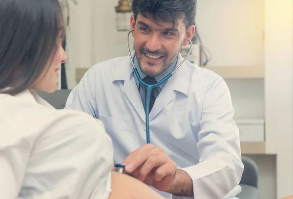 doctor measures the pressure of a pregnant woman with stethoscop