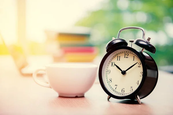 Relógio de alarme retro com xícara de cappuccino na mesa no escritório, Cof — Fotografia de Stock