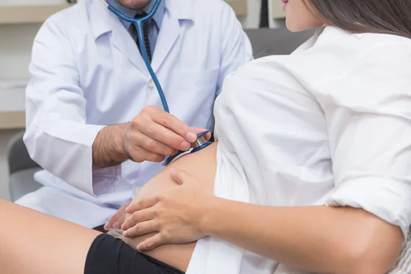 Medico misura la pressione di una donna incinta con stethoscop — Foto Stock