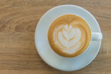 Latte art kahve ya da ahşap masa zemininde kapuçino.