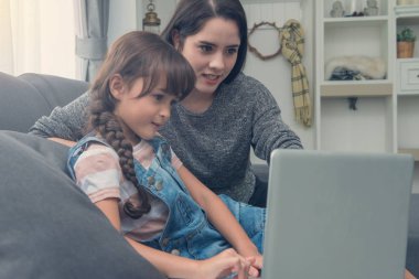 Güzel genç anne ve kızı kanepe h notebook kullanıyorsanız