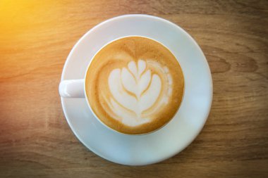 Latte art kahve ya da ahşap masa zemininde kapuçino.