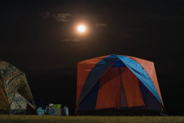 Kamptaki çadır çayırların arasında ay ışığı ve gece vakti