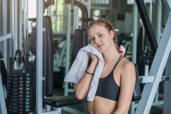 Esportes mulher cansada após o exercício limpa o suor no rosto na aptidão — Fotografia de Stock