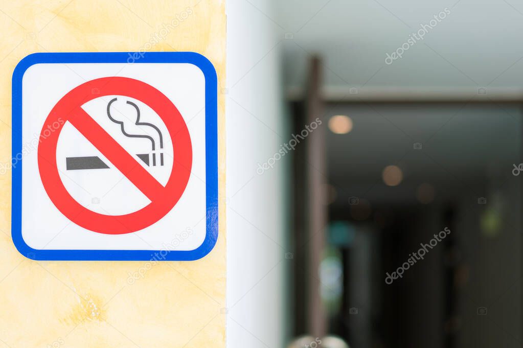 No smoking sign on cement wall to the apartment building