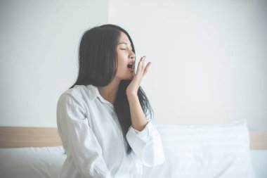 Güzel genç kadın uyanmak ve sabah kendini germek