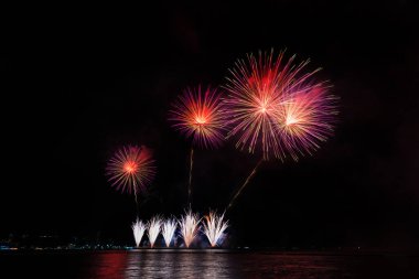 Geceleyin çeşitli renklerde renkli havai fişekler ve kutlama ve yıldönümü konsepti.