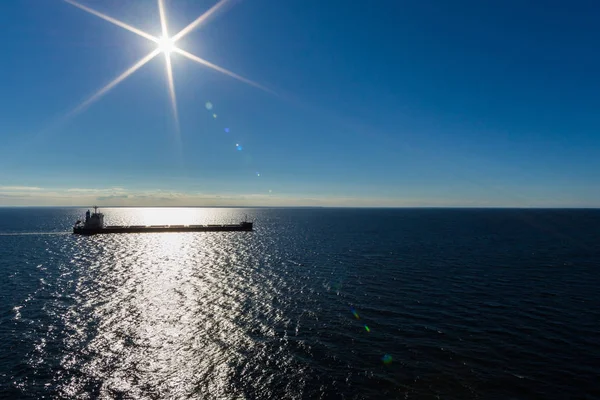 cargo ship in deep blue sea and ska with sun shining