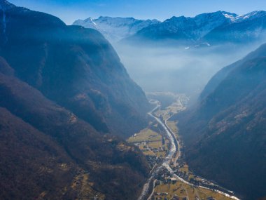 Ticino 'daki Maggia vadisinde karla kaplı dağlar ve mavi gökyüzü.