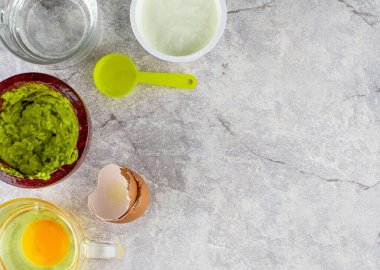 Ev yapımı spa için yüz maskesi, bir fincan yoğurt, yarım bardak avokado ezilmiş yumurta, bir çay kaşığı hindistan cevizi yağı, sonra hepsini karıştırın. düz üst görünümde yatıyordu.