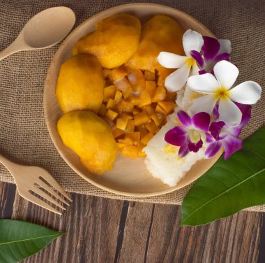 Tahta tabakta mango yapış yapış pirinç. Tahta masanın üstünde.