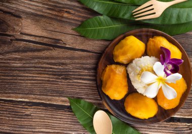 Mangolu pilav Tayland tatlısıdır. Yabancıların çoğu Tayland 'a geldiklerinde sipariş vermeyi sever. bu menü için ahşap tabağa servis yapın.. 