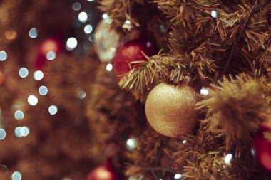 Bulanık arka planda dekore edilmiş Noel ağacı. Noel süsü. Çam dallarına kırmızı toplar asmak Noel ağacı çelengi ve süslemeleri soyut bokeh arka planında fotokopi alanı ile birlikte asmak