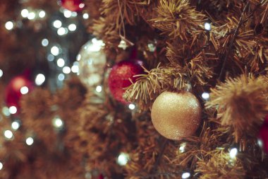 Bulanık arka planda dekore edilmiş Noel ağacı. Noel süsü. Çam dallarına kırmızı toplar asmak Noel ağacı çelengi ve süslemeleri soyut bokeh arka planında fotokopi alanı ile birlikte asmak