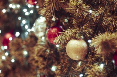 Bulanık arka planda dekore edilmiş Noel ağacı. Noel süsü. Çam dallarına kırmızı toplar asmak Noel ağacı çelengi ve süslemeleri soyut bokeh arka planında fotokopi alanı ile birlikte asmak
