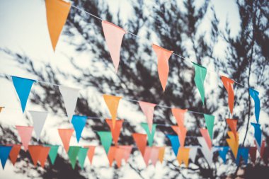 Beyaz arka planda renkli kağıt kiraz kuşu parti bayrakları var. Bayraklı karnaval çelengi. Doğum günü kutlaması, festival ve güzel dekorasyon için dekoratif parti flamaları. Tatil