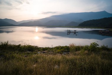 Dağ, gökyüzü ve nehir sakin ve serin bir atmosferde. Benzer renk şeması. Göl manzaralı mavi dağlar. Sukhothai Tayland 'da göl kenarındaki mavi dağların manzarası