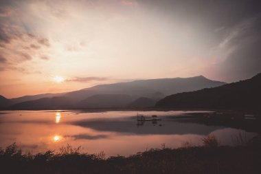 Dağ, gökyüzü ve nehir sakin ve serin bir atmosferde. Benzer renk şeması. Göl manzaralı mavi dağlar. Sukhothai Tayland 'da göl kenarındaki mavi dağların manzarası