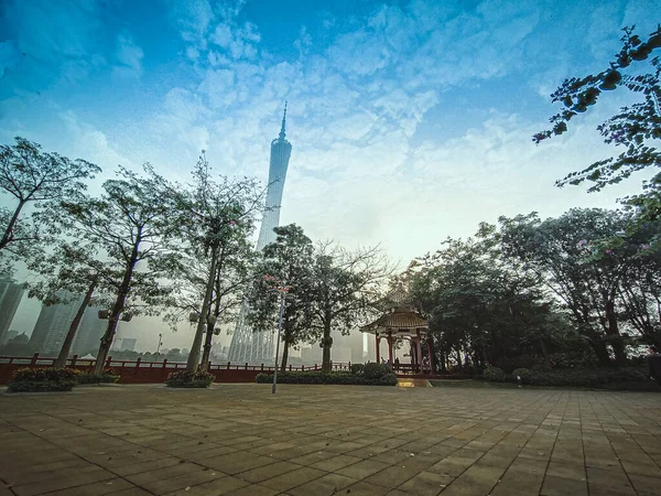 The Canton Tower formally Guangzhou TV Astronomical and Sightseeing. Viewed from the front entrance of Park with traditional Chinese Pavilion. New and old architecture in frame.