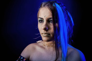 Mavi ışıkta siyah arka planda etnik kız