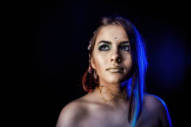 Mavi ışıkta siyah arka planda etnik kız