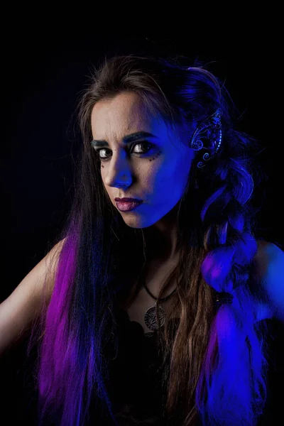 Girl in werewolf style on a black background with blue light.