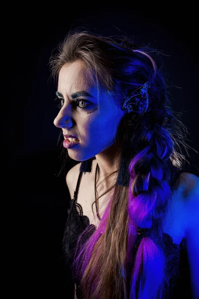 Girl in werewolf style on a black background with blue light