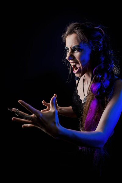 Girl in werewolf style on a black background with blue light